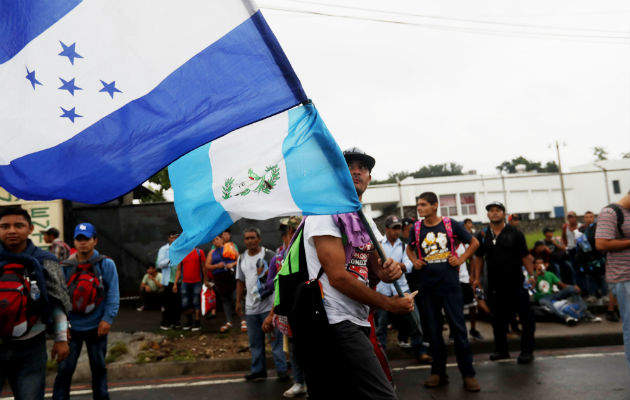  Un migrante hondureño ondea las banderas de Guatemala y Honduras durante su trayecto en la caravana de migrantes. EFE