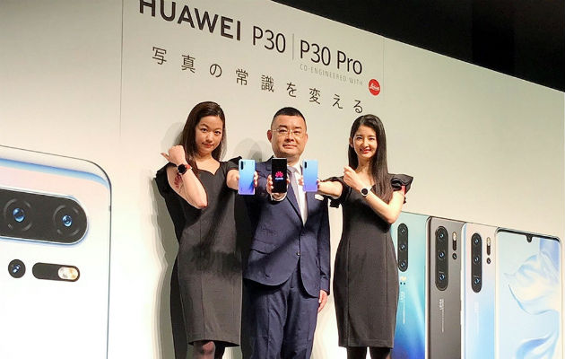 Un experto tecnológico de Huawei Wu Bo (c) muestra uno de sus productos en Tokio. Foto: EFE.