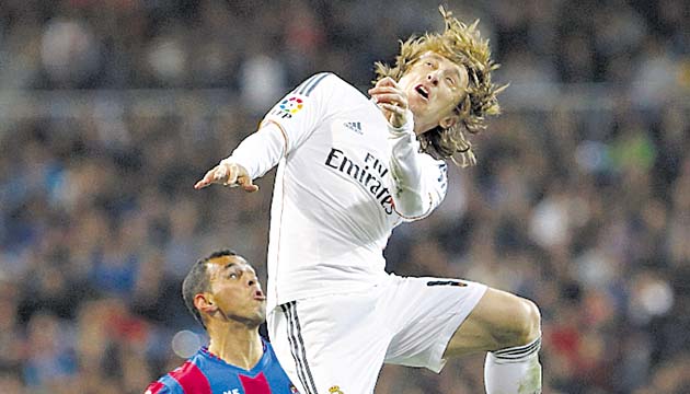 Luka Modric (dcha.) en su intento de cabecear el balón.(EFE)