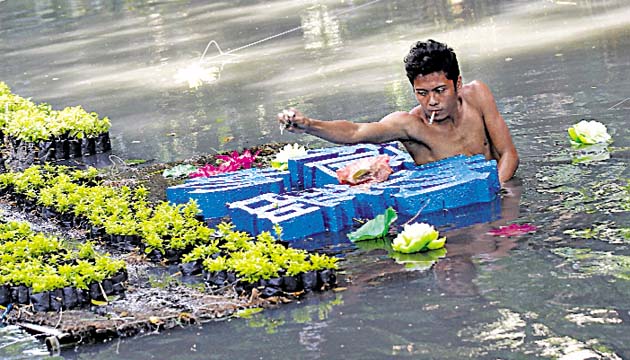 Ecologista filipino planta flores en aguas contaminadas del río Pasig.(EFE)