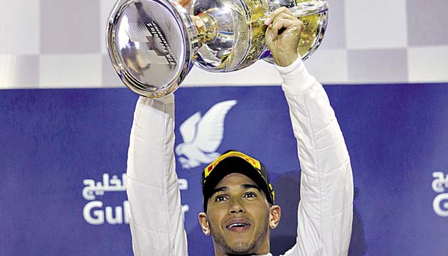 Hamilton levanta la copa que lo certifica como el triunfador.(AP)