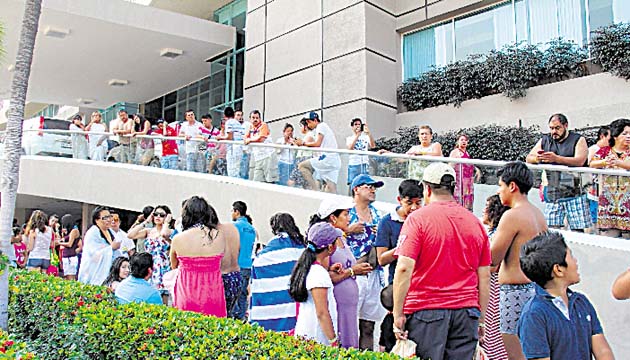 Turistas del puerto de Acapulco permanecen fuera de un hotel.(EFE)