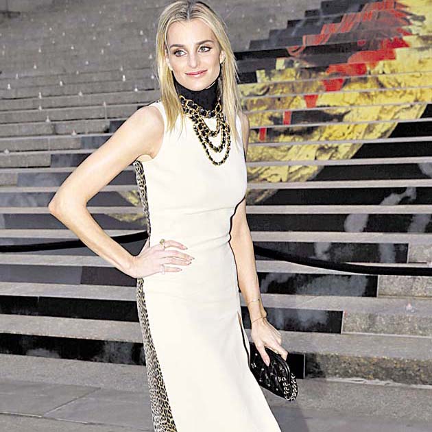 Katie Nehra. Hermosa con este vestido de color marfil con abertura en la zona izquierda y detalles de “animal print”. El cuello, alto y negro, con cadenas al estilo Chanel.