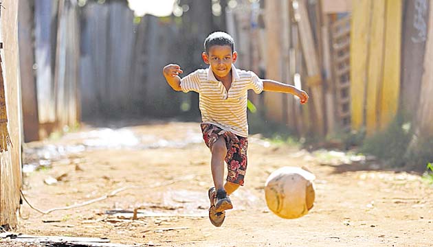 Un pequeño juega con su balón de fútbol en una de las polvorientas calles de la favela Santa Luzia, en Brasilia.(AP)