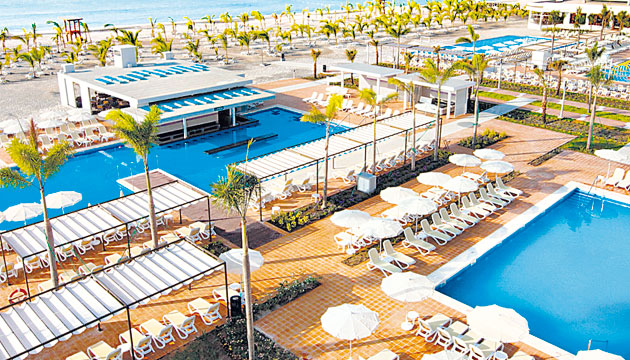 Complejo hotelero con amplios jardines y espacios para caminar. El área de las piscinas cuenta con salvavidas.