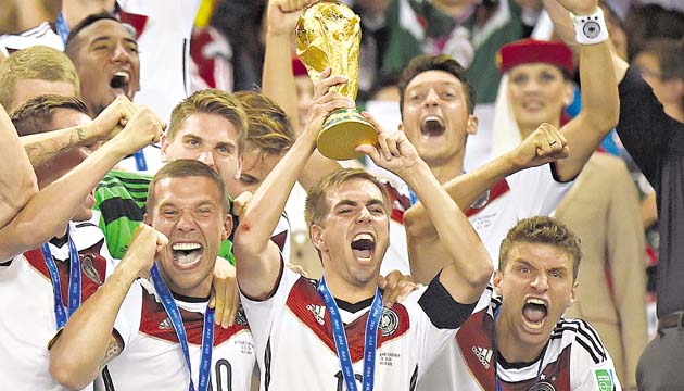 El capitán y defensor de la selección de alemana, Philipp Lahm (centro), levanta el trofeo que adjudica al equipo dirigido por Joachim Löw como el campeón de la Copa del Mundo de Brasil 2014.(AP)