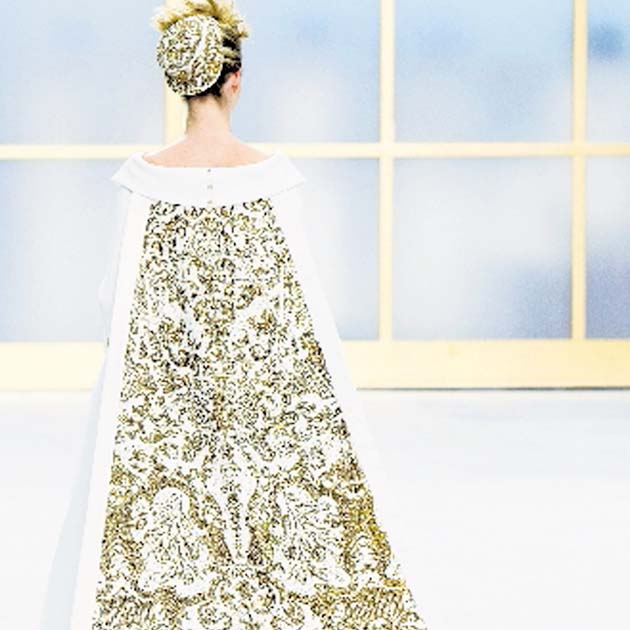 Novia Chanel. Rememoró el pasado con un vestido decorado con botones dorados y cubierto con una larga capa de brocados.