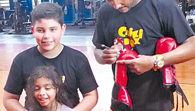 El supercampeón mundial firma unos guantes para obsequiarlos.(Cortesía)