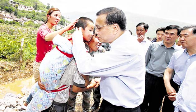 El primer ministro chino, Li Keqiang, consuela a un niño.(AP)