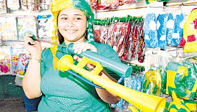 Productos. Esta colaboradora de Vendelas muestra uno de los muchos objetos que hay en el mercado nacional en conmemoración del Mundial.(Anayansi Gamez)
