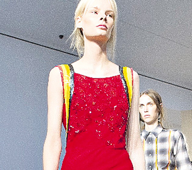 Rojo pasión. Esta modelo luce un glamuroso vestido de color rojo vibrante, el cual no pasará de moda. Detalles en amarillo.