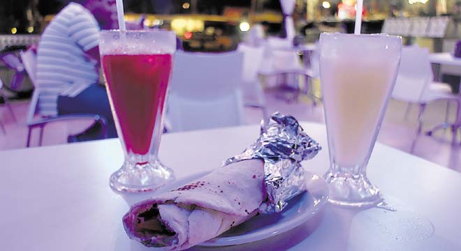 Rico shawerma o gyro, acompañado de jugo, listo para disfrutar.