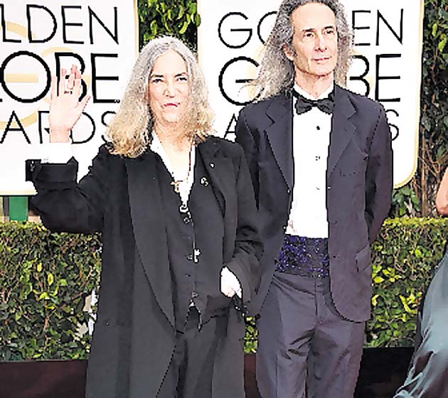 Informal. Patti Smith y Lenny Kaye (mujer y hombre) parecían dos caballeros en la alfombra. Un estilo muy “hippie” e informal para ambos. ¡Out!