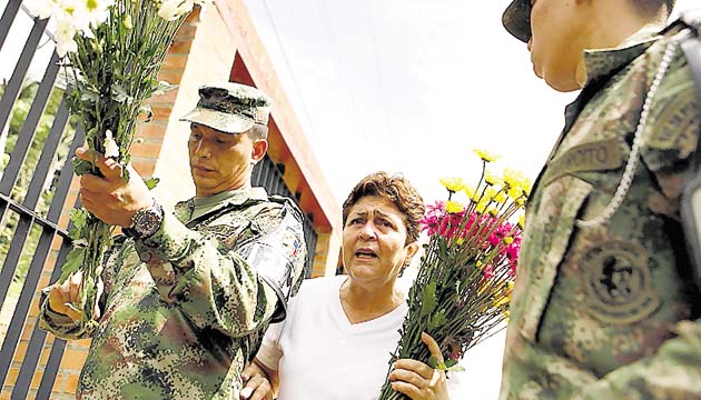 Una mujer deja flores para las víctimas.(EFE)