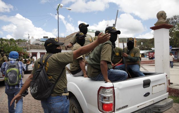 Policías comunitarios se retiran del área de una protesta.