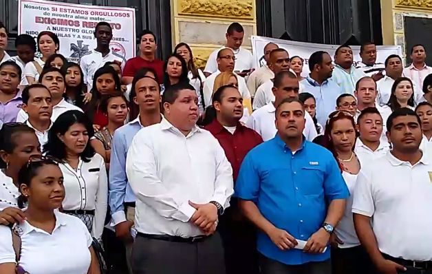 Egresados del Instituto Nacional entonaron las notas de su himno en las escalinatas de su colegio y colocaron pancartas en las puertas del colegio pidiendo "todo el peso de la ley" para los responsables de los hechos. / Cortesía Fiscalía interviene en caso de institutores revoltosos