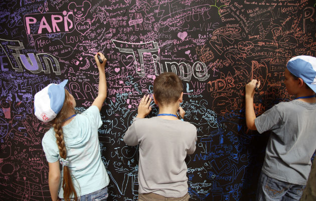 Firman su nombre y dibujar en un tablero gigante. Foto/ AP