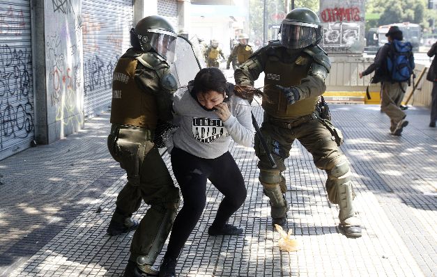 Policías antidisturbios detienen a una estudiante. / EFE Policías antidisturbios detienen a una estudiante. / EFE