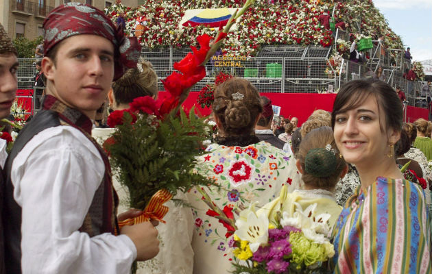 Dos jóvenes ataviados con trajes regionales participan en la tradicional Ofrenda de Flores a la Virgen del Pilar de Zaragoza, para componer un inmenso manto de color a la Patrona de la Hispanidad. EFE/Javier Cebollada