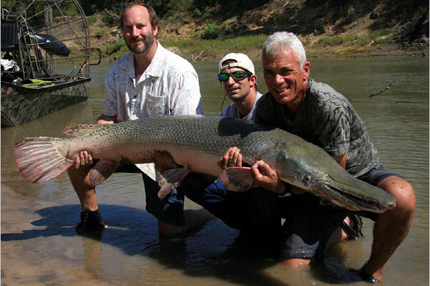 Jeremy Wade sostiene un pez lagarto junto a otros dos exploradores / Foto: redes sociales.