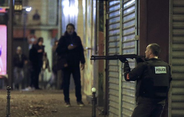 Un gendarme francés se coloca en posición para disparar, mientras un hombre lo mira en momentos que la tensión abarcaba la capital del Estado galo.  / EFE