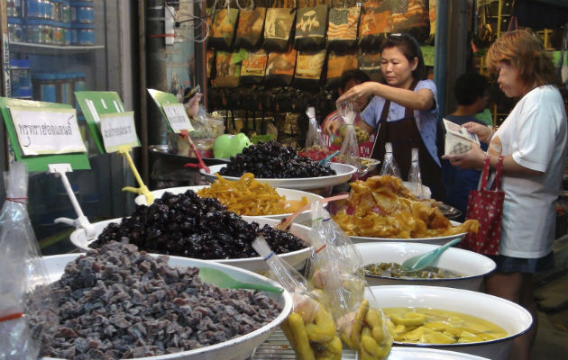 Una vendedora prepara una bolsa de encurtidos para una clienta. Foto/ EFE