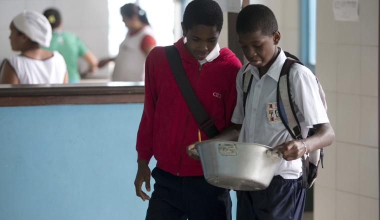 Jóvenes  estudiantes reciben algo de comida. /Foto AP