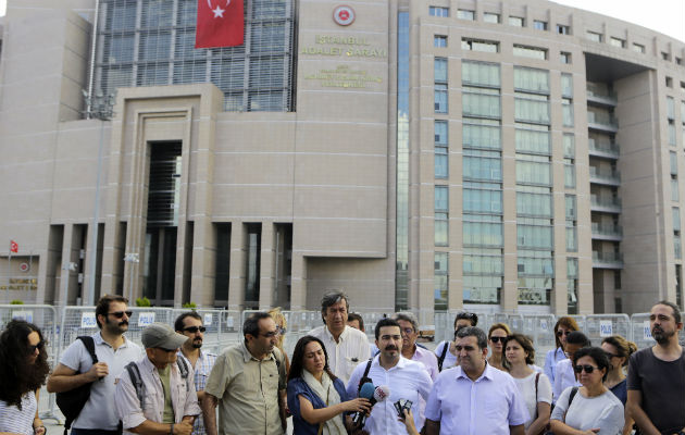 Un grupo de periodistas se reúnen fuera de un edificio de la corte para apoyar a su colega periodista Bulent Mumay, que fue detenido. FOTO:AP