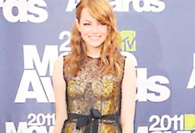 Emma Stone: lució divina con este minivestido de encaje amarillo con transparencias negras y una cinta a la altura de la cintura. Estilo juguetón y “sexy” a la vez.
