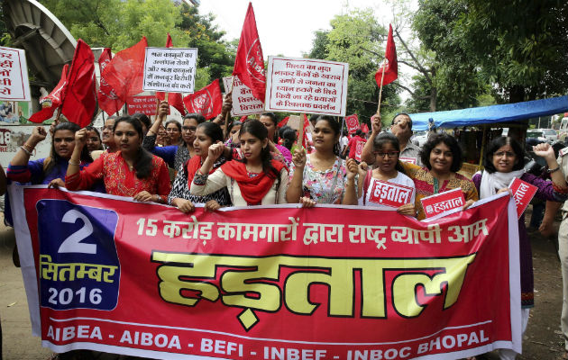 Trabajadores sujetan pancartas de la asociación de trabajadores de bancos de la India durante una huelga general convocada por sindicatos en Bhopal, en la India. Foto: EFE