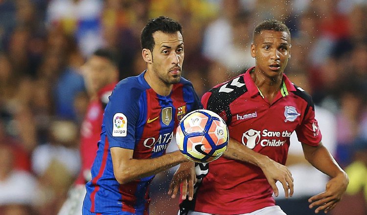 Sergio Busquets (izq.) disputa el balón en la mediacancha. /Foto EFE