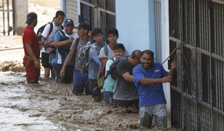 Un grupo de personas tratan de ponerse a salvo. /Foto EFE