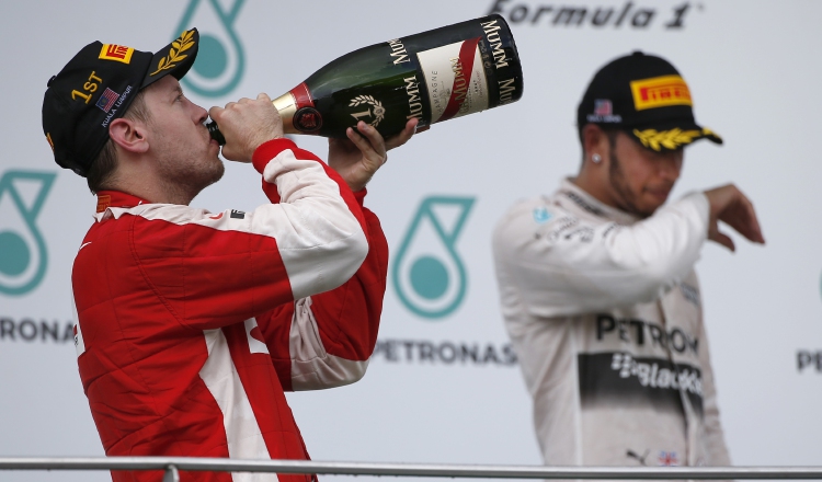 Sebastian Vettel (izq.) celebra un triunfo ante Lewis Hamilton. /Foto AP