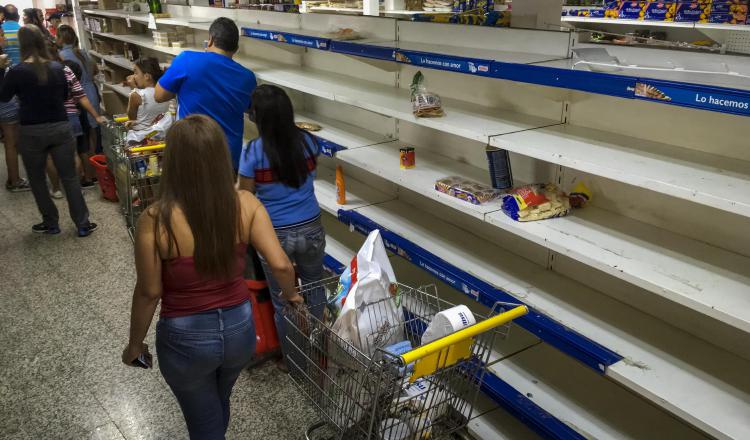 Buscan algún alimento en los supermercados de Caracas. EFE
