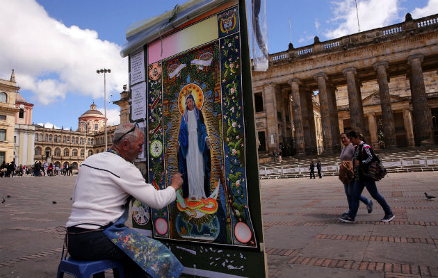 Diego Arcila Grajales da las últimas pinceladas al cuadro de la Virgen de la Medalla Milagrosa. FOTO/EFE