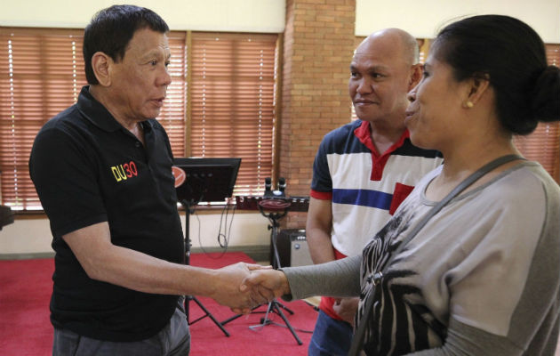 Rodrigo Duterte junto a los padres de joven muerto. Foto/ EFE