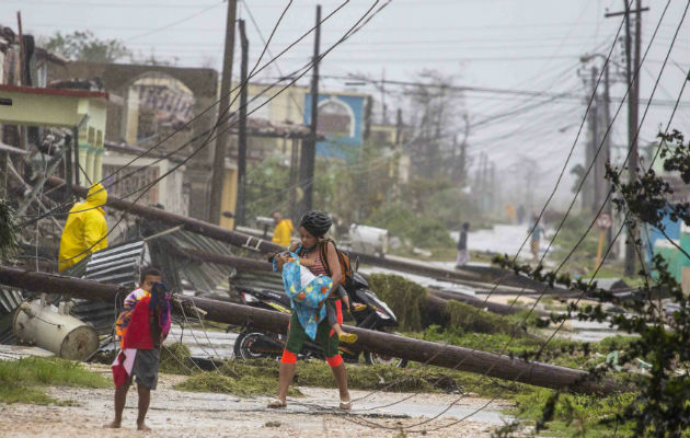 Una mujer entre postes derribados por Irma en Caibarien, Cuba. Foto: AP. 