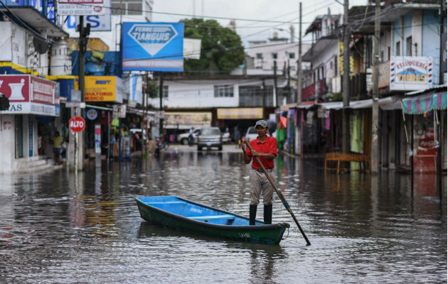 Un hombre se traslada en un bote por las inundaciones causadas por Ramón. Foto: EFE.    