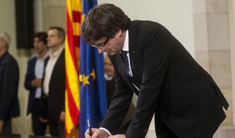 Carles Puigdemont firma el documento sobre la Independencia ante el  Parlamento regional. /Foto EFE