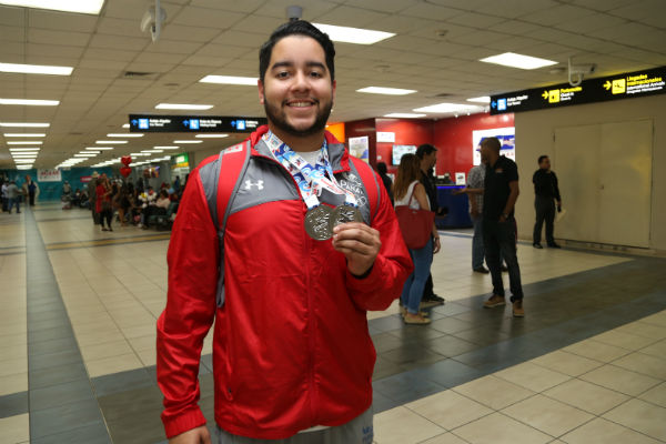 Lee muestras sus medallas de plata.