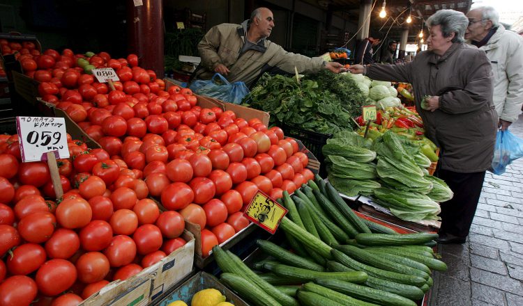 Una mujer compra frutas y verduras en un puesto de verduras y legumbres. EFE