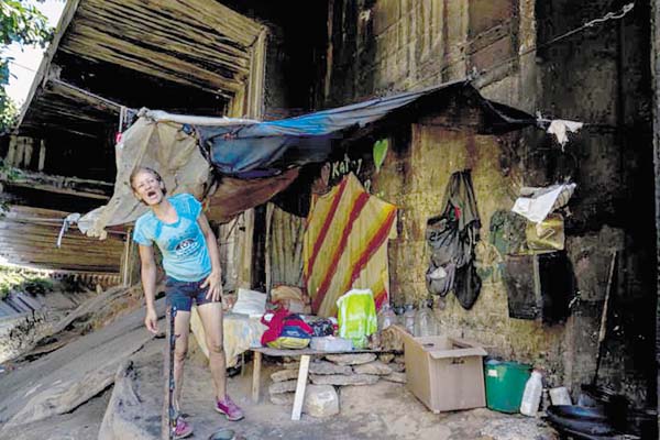Katerin llamando a Eduardo en su casa debajo de un puente en la ciudad de Caracas. /Foto EFE