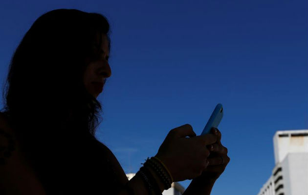 Una mujer mira su teléfono móvil.