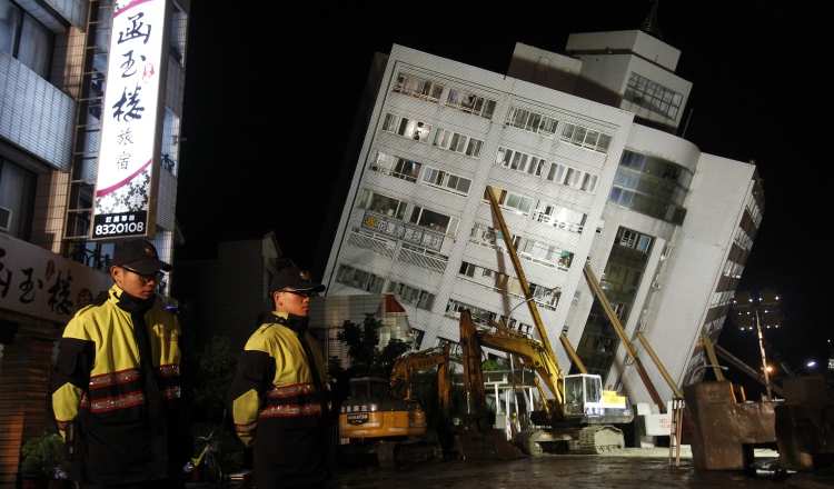 Oficiales vigilan el área donde se llevan a cabo labores de rescate. AP