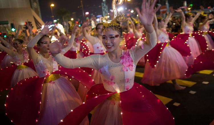 1. Mujeres disfrazadas danzan durante el desfile.