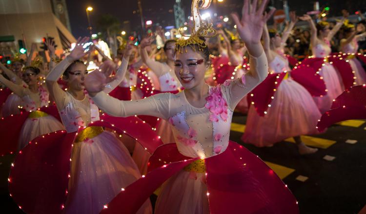 1.  Mujeres disfrazadas danzan durante el desfile.