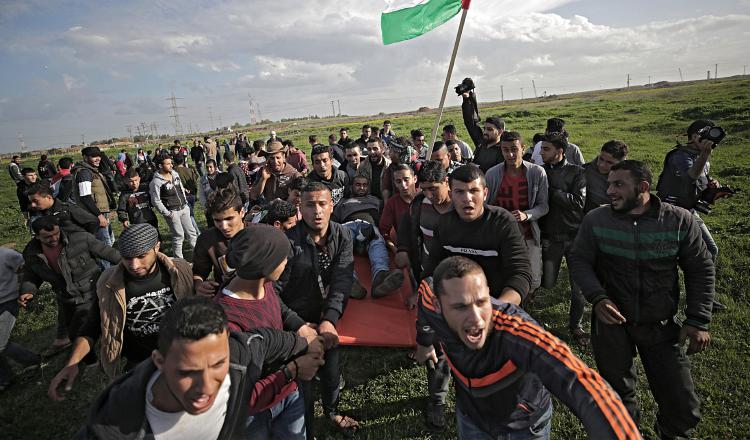 Palestinos desplazan a un herido durante enfrentamientos ayer con tropas israelíes. EFE