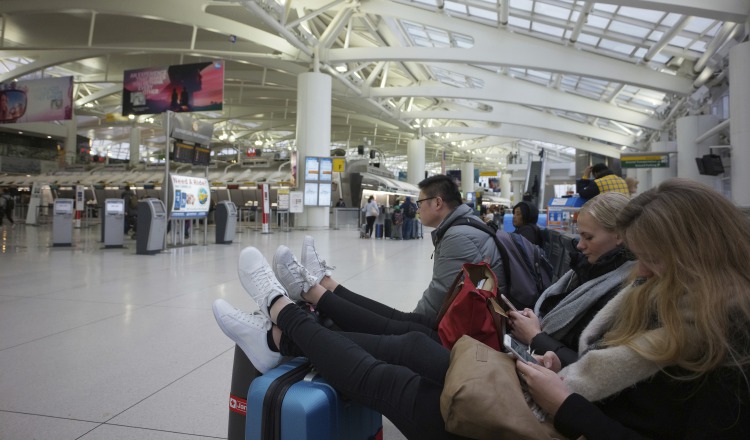 Un grupo de personas se mantienen en la sal de espera del Aeropuerto Internacional JFK. AP