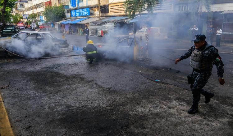 Apagan autos incendiados. EFE