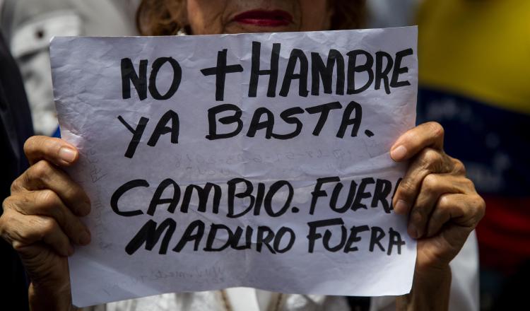 Una mujer muestra un cartel durante una de las manifestaciones en contra de las presidenciales. EFE